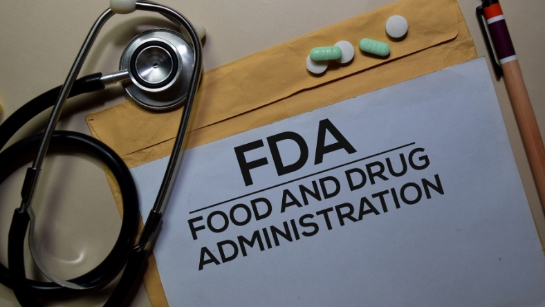 FDA paperwork on desk with stethoscope and medication capsules