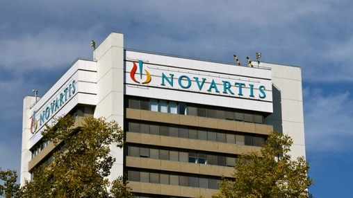 Novartis headquarters building showing the company logo on the upper facade and a second sign on the side
